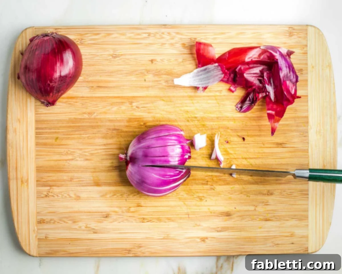 Vibrant Apple Fennel Farro Salad with Pomegranate Gems 8 Detailed step-by-step image showing how to peel and precisely dice a red onion into small, fine pieces, ideal for a raw salad.