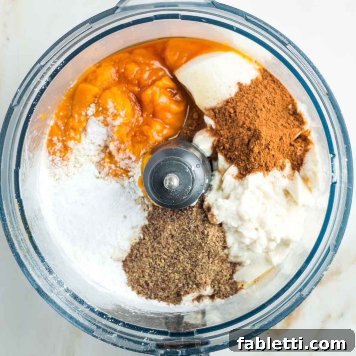Effortless Vegan Pumpkin Pie with a Homemade Dairy-Free Crust 13 All the vegan pumpkin pie filling ingredients—pumpkin puree, silken tofu, arrowroot, flax, maple syrup, and spices—gathered in the bowl of a food processor, ready for blending.