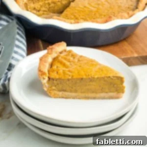 Effortless Vegan Pumpkin Pie with a Homemade Dairy-Free Crust 20 A side view of a perfectly sliced vegan pumpkin pie, showcasing its smooth texture and golden crust.