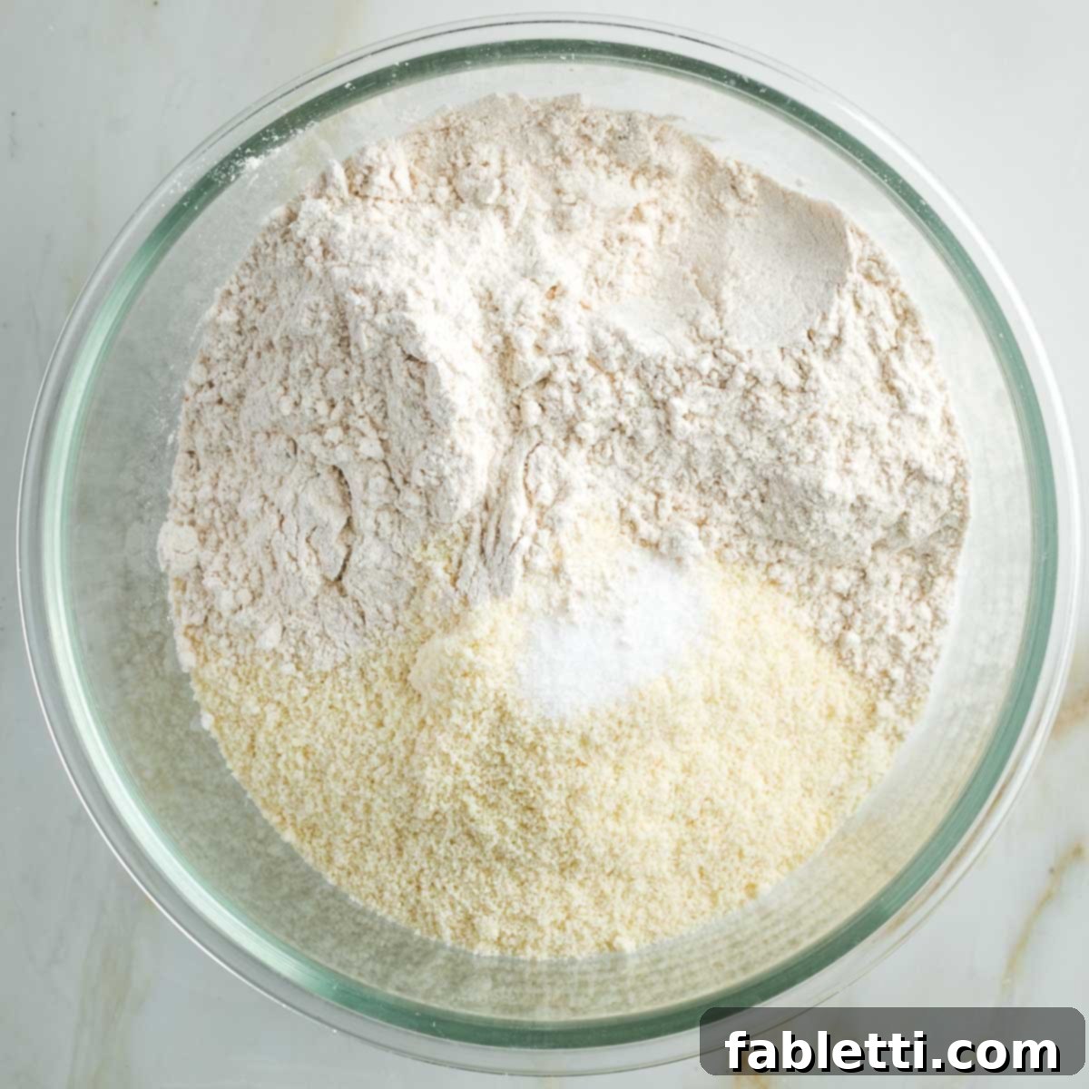 Effortless Vegan Pumpkin Pie with a Homemade Dairy-Free Crust 5 A glass bowl holds the dry ingredients for the vegan pie crust: almond flour, all-purpose flour, and a pinch of salt, mixed together.