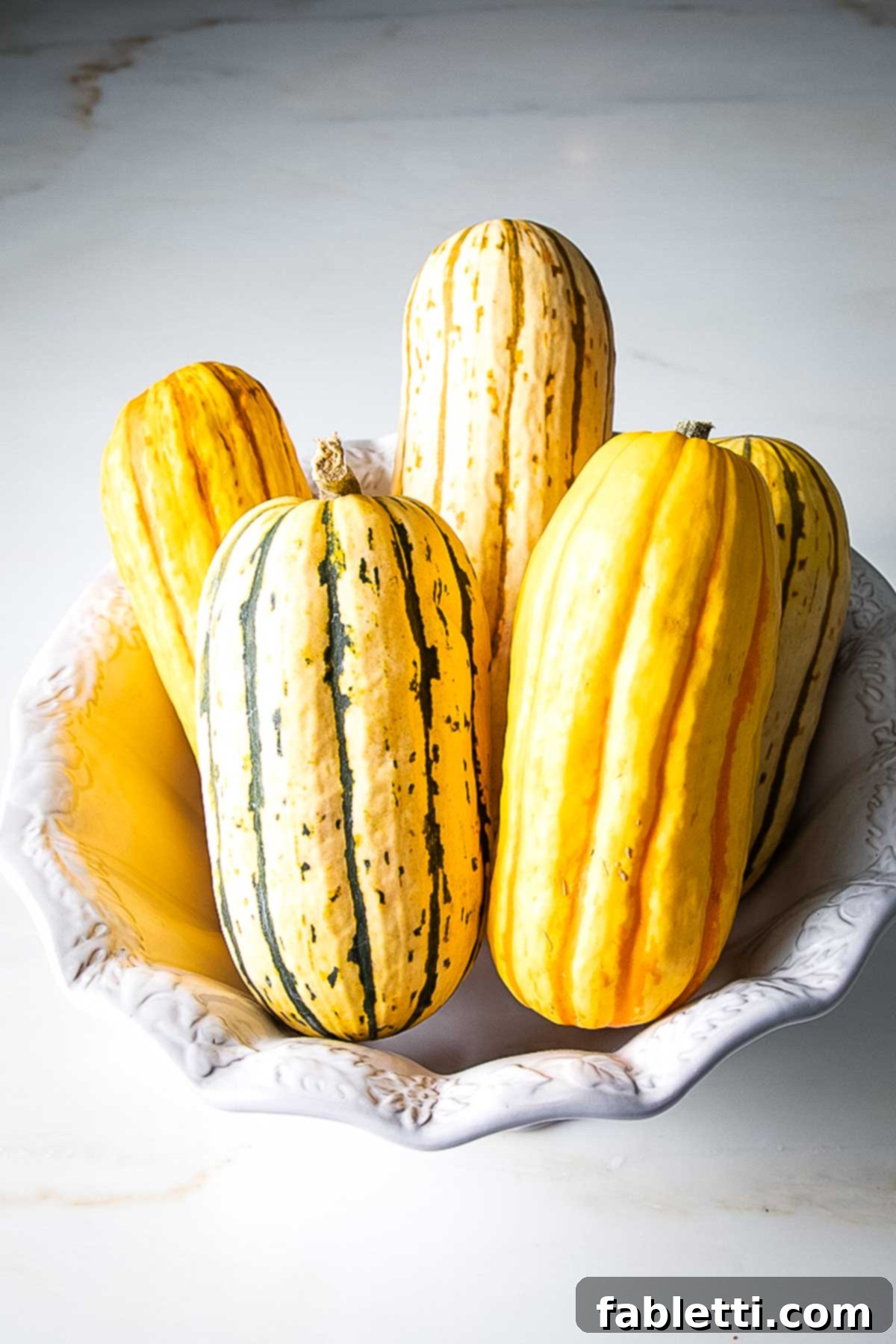 Golden Roasted Delicata Squash 3 Bowl of different colors and sizes of delicata squash.