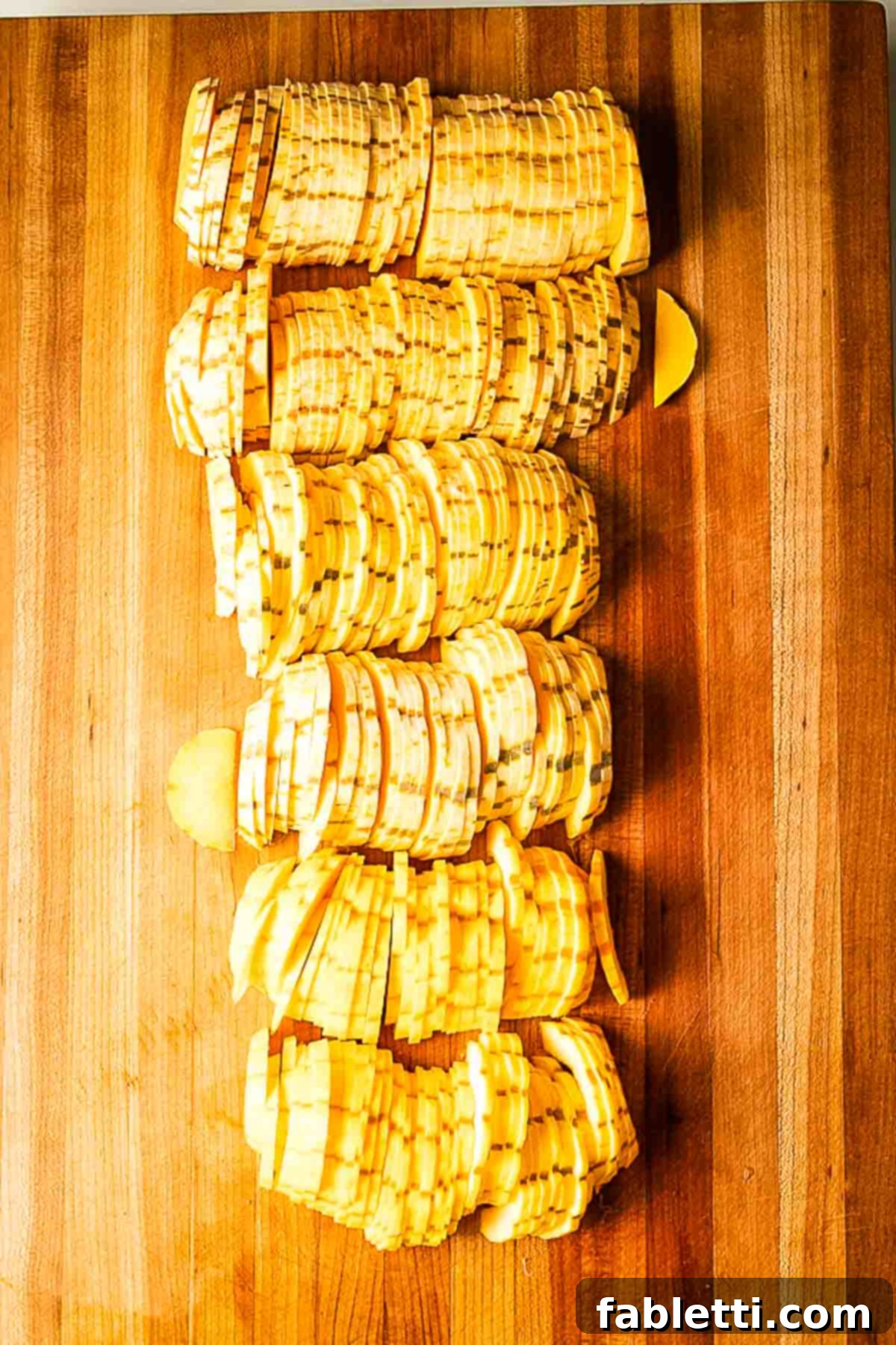 Golden Roasted Delicata Squash 7 Cutting board filled with thin half moon slices of delicata squash.
