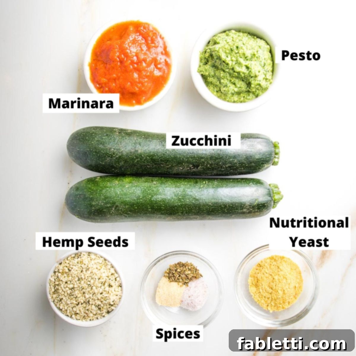 Mini Zucchini Pizzas 4 Labeled ingredients: marinara, pesto, zucchini, hemp seeds, nutritional yeast, spices.