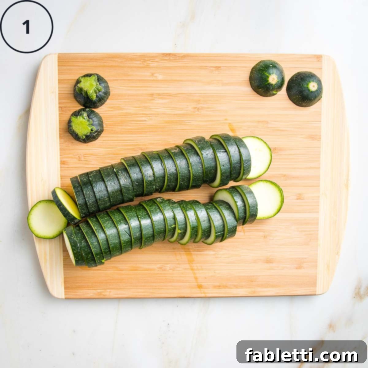 Mini Zucchini Pizzas 5 2 Zucchinis sliced into ¼" rounds on a wooden board.