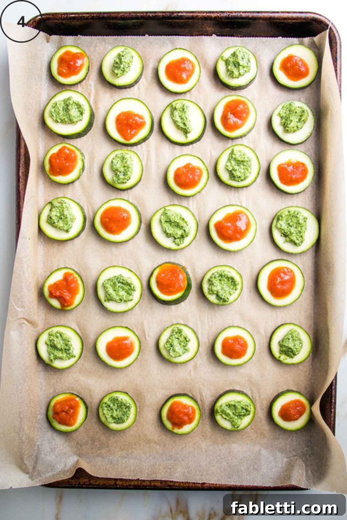 Mini Zucchini Pizzas 8 Baking tray with rows of sliced zucchini rounds topped with marinara or pesto.