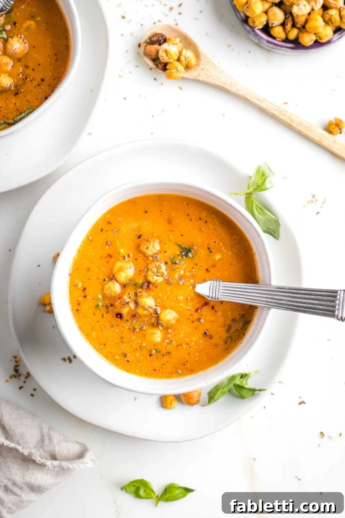 Creamy Vegan Tomato Soup 14 Bowl of creamy tomato soup with chickpea croutons and fresh basil.