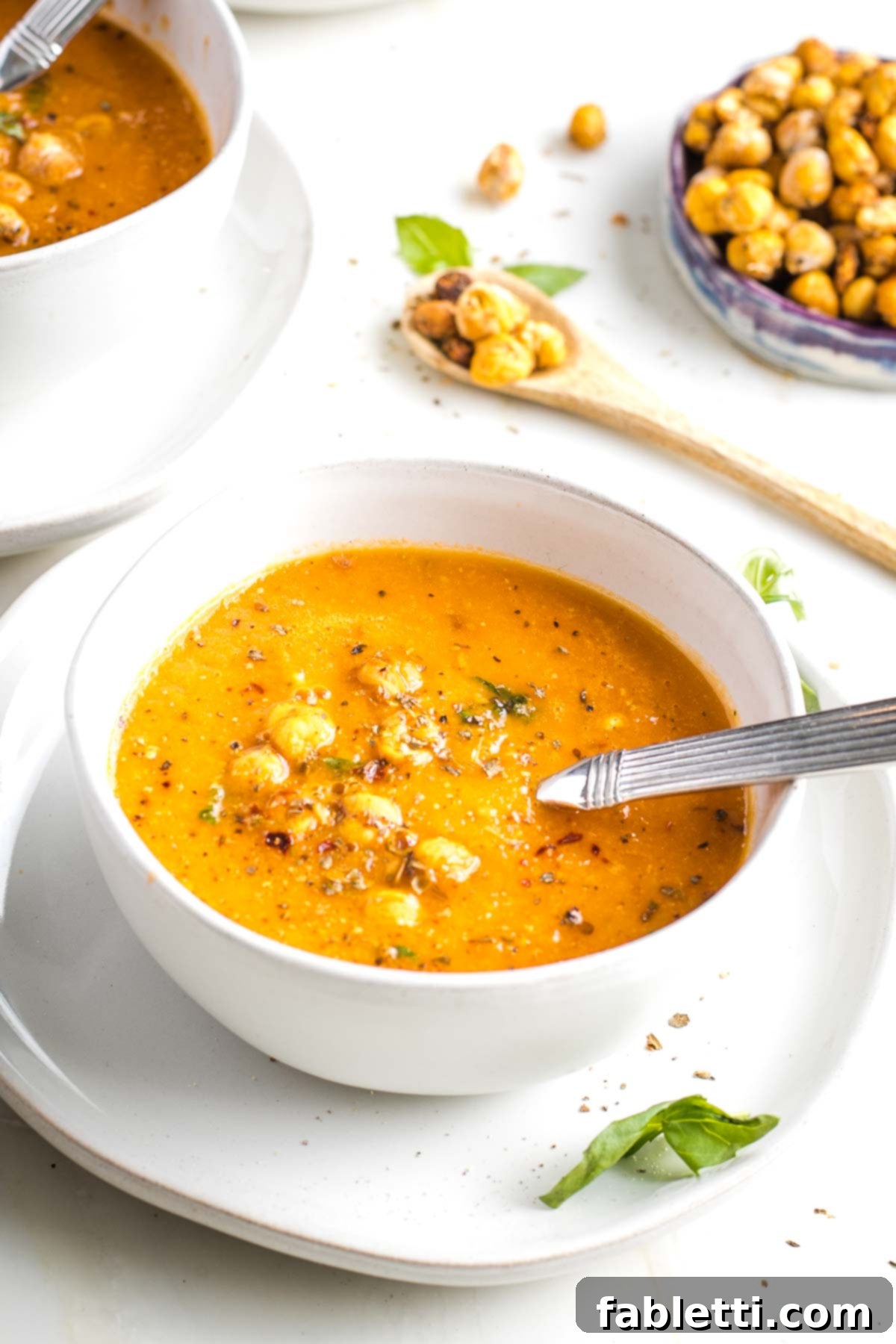 Creamy Vegan Tomato Soup 3 A bowl of creamy tomato soup topped with crunchy chickpea croutons and fresh basil.