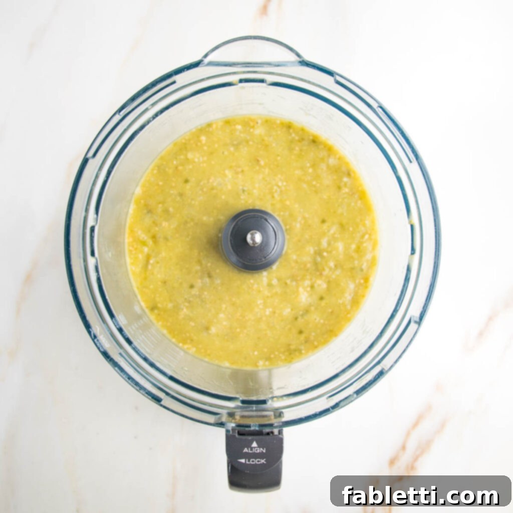 Fire-Kissed Tomatillo Salsa Verde 9 The food processor bowl with fully blended salsa verde, showing smooth texture.