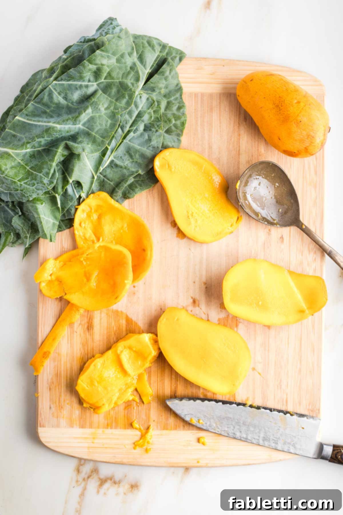 Cutting mangoes and scooping out their pulp.