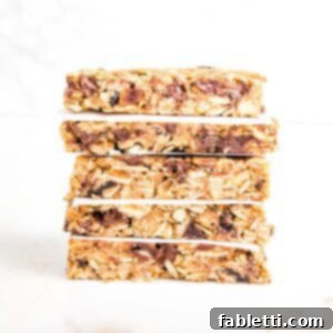 Golden Baked Granola Bites 21 A stack of crunchy granola bars, with parchment paper in between layers.