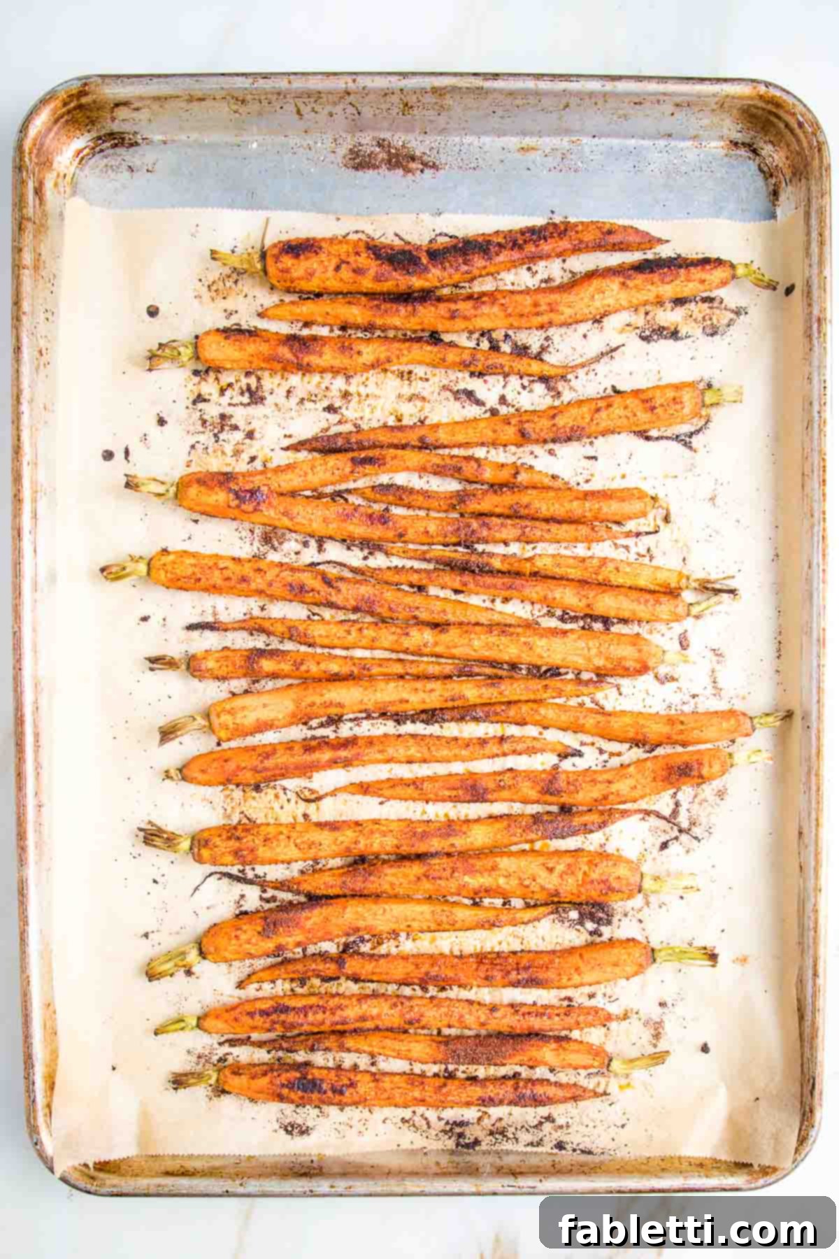 Roasted and spiced carrots on a parchment lined baking tray