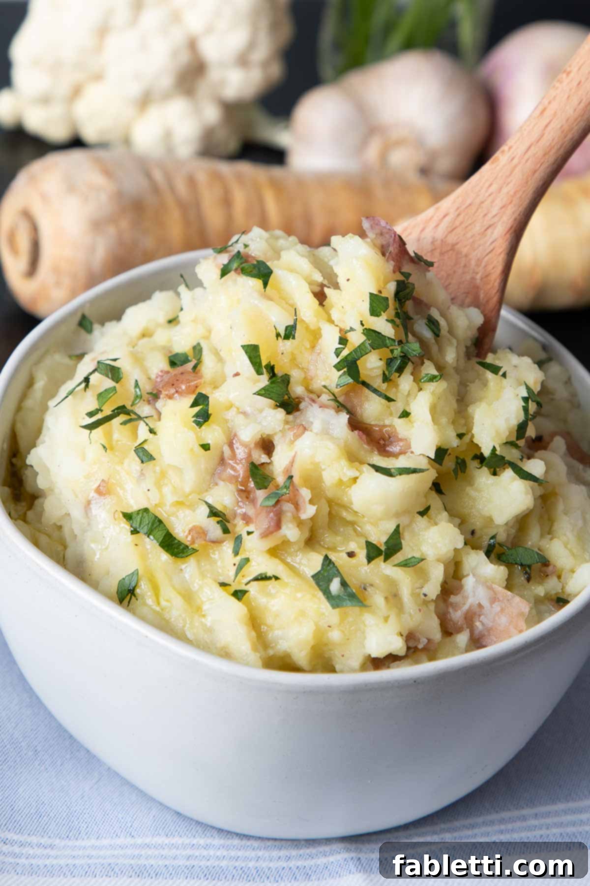 Heavenly Dairy-Free Garlic Mash 2 A rustic bowl of chunky dairy-free garlic mashed potatoes, showing hints of the potato skins, elegantly topped with fresh green herbs for a pop of color and flavor.