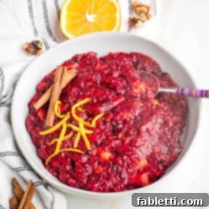 Refined Sugar-Free Cranberry Sauce 14 Bowl of chunky cranberry sauce with orange peel and cinnamon sticks.