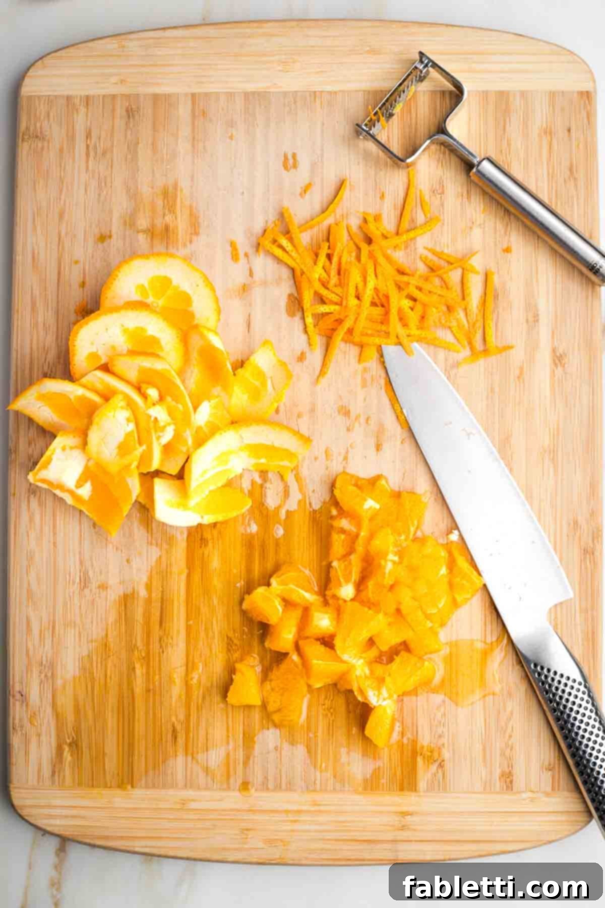 Refined Sugar-Free Cranberry Sauce 5 A second orange, with long, delicate strips of zest peeled using a julienne peeler. The remaining white pith has been removed, and the vibrant orange flesh is roughly chopped, ready to be added to the sauce.