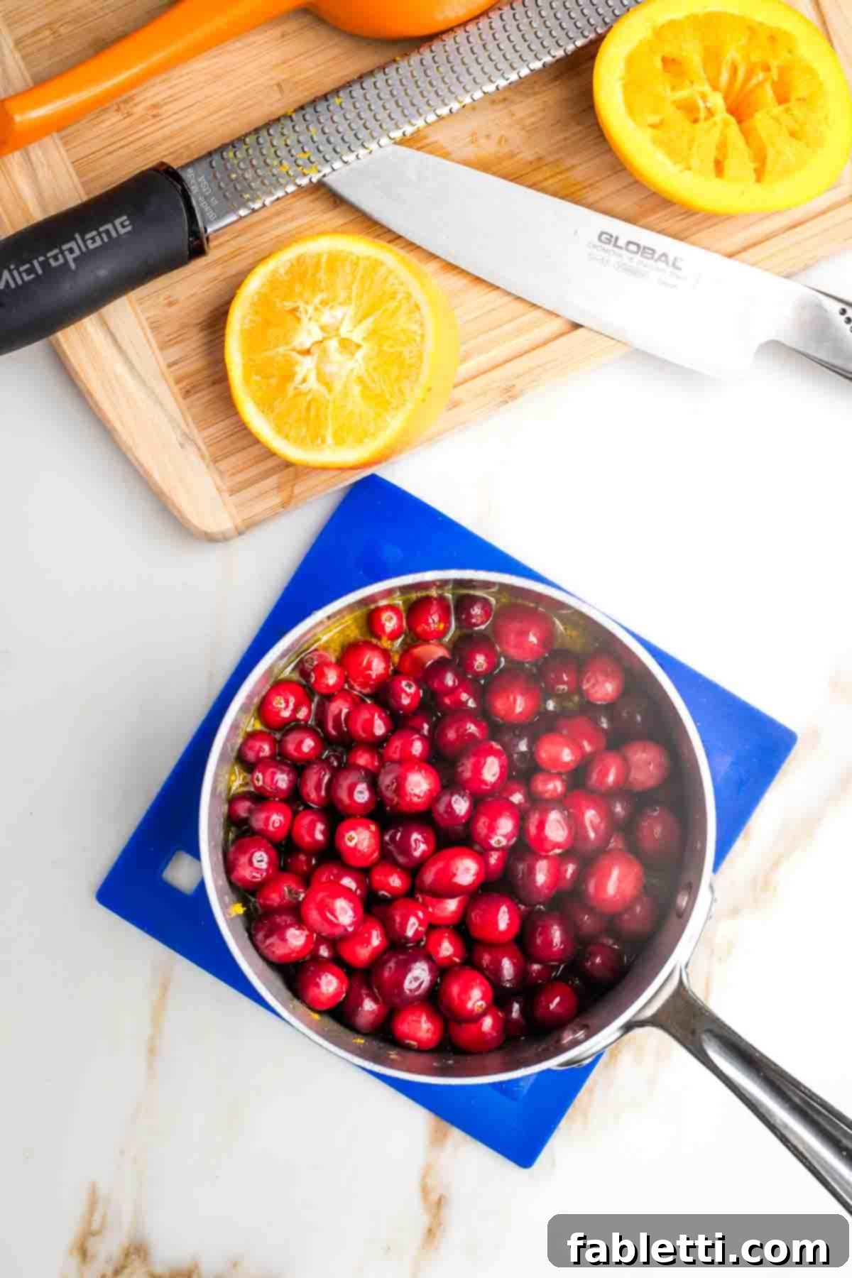 Refined Sugar-Free Cranberry Sauce 6 A small saucepan containing a mixture of freshly rinsed cranberries, bright orange juice, and delicate orange zest, ready to be heated and transformed into a delicious sauce.