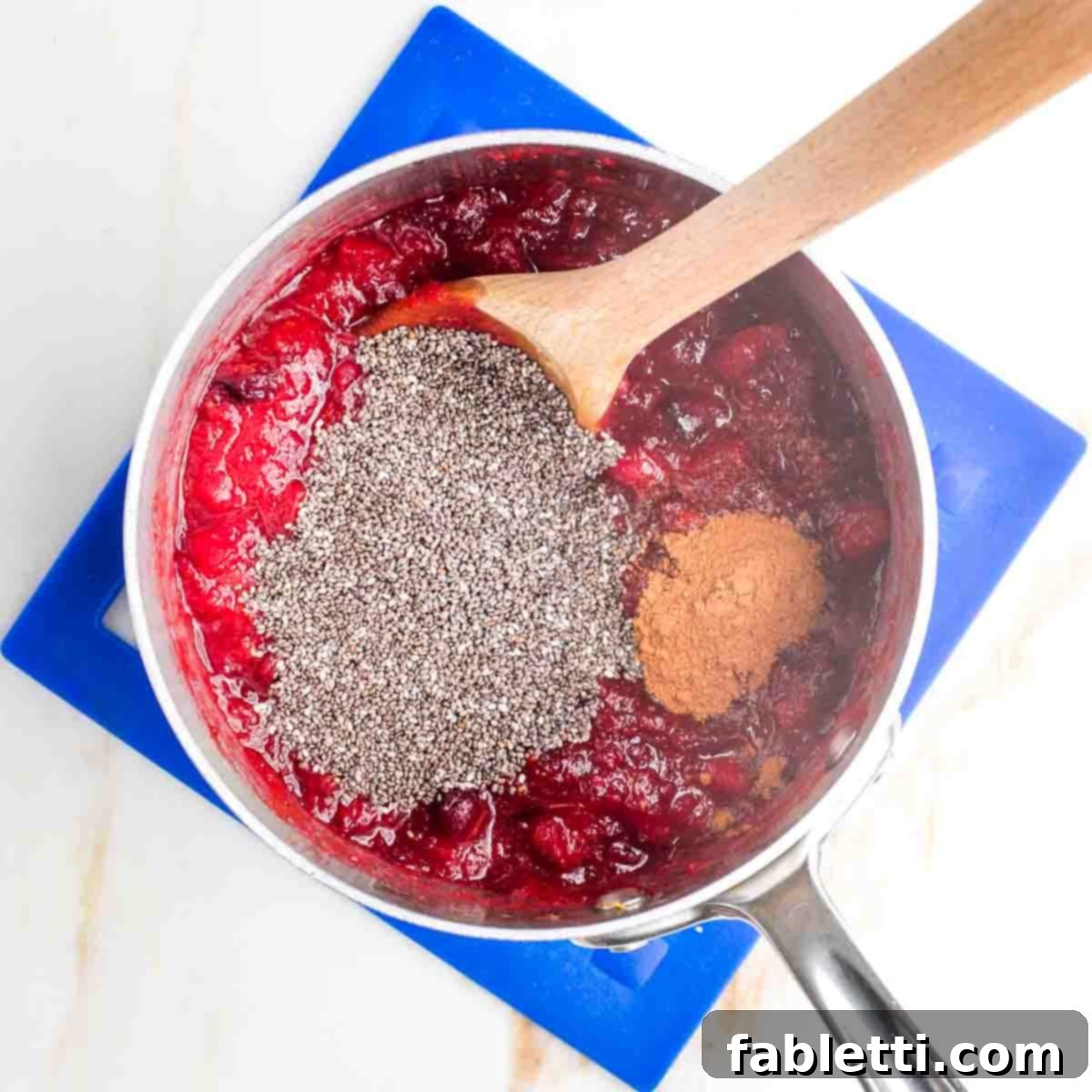 Refined Sugar-Free Cranberry Sauce 9 A small pot of cooked cranberries, infused with the warm spices of cinnamon, now enriched with tiny chia seeds, awaiting the final additions of fresh orange and toasted walnuts.