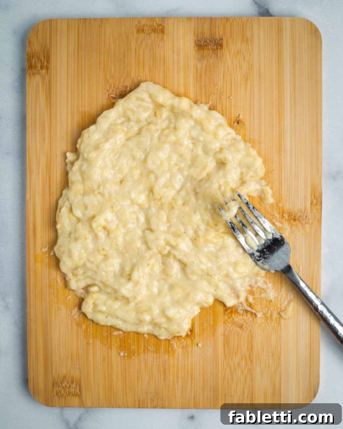 Mashed bananas, completely smooth and free of chunks, resembling a liquidy paste, ready to be incorporated into the batter.