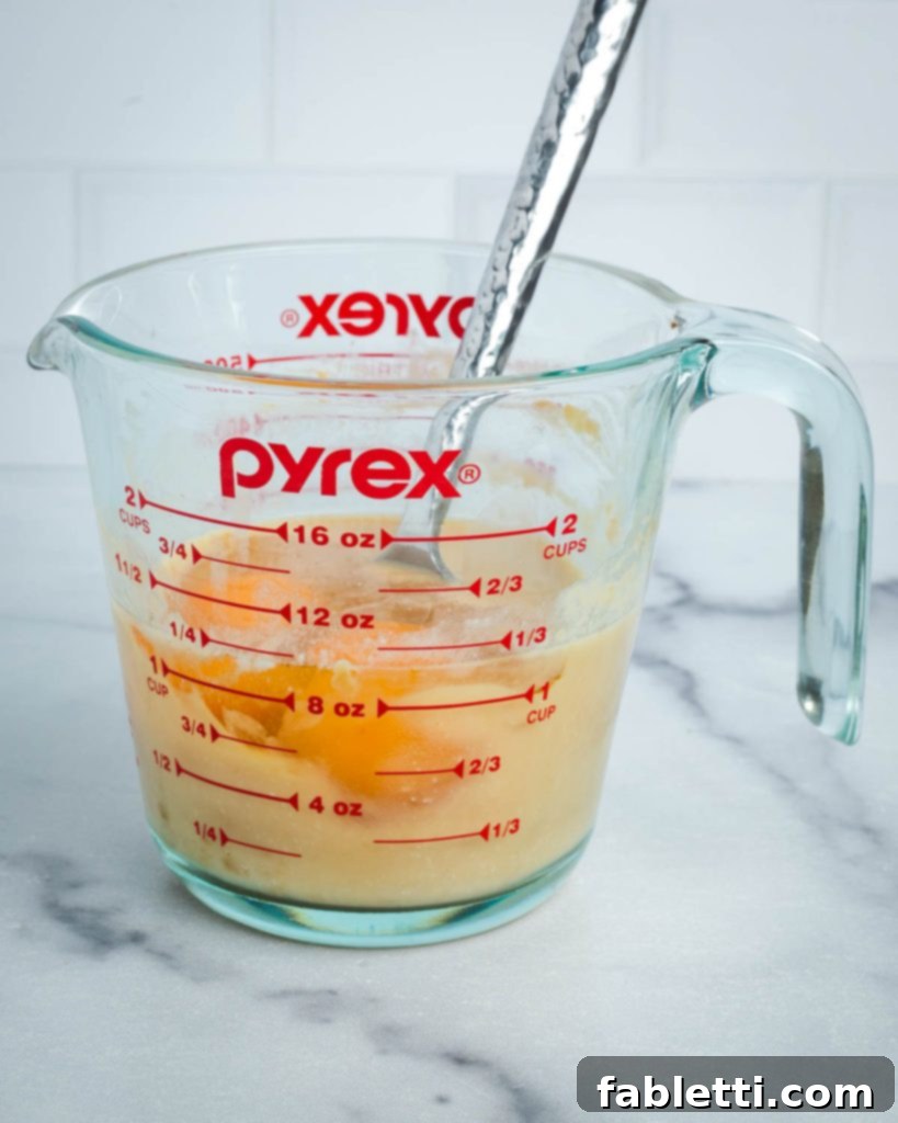 Eggs or flax eggs added to the miso and almond milk mixture, ready for stirring until fully combined.