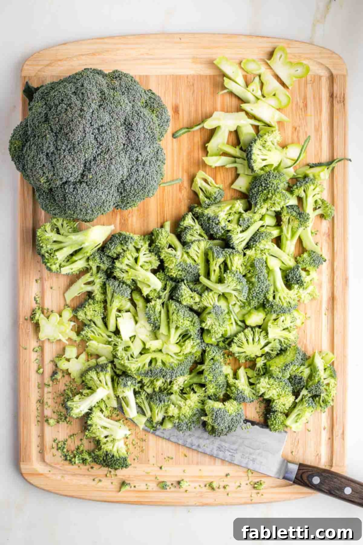 Velvety Plant-Based Broccoli Soup 6 Head of broccoli, plus another crown that's been trimmed on a wood cutting board.