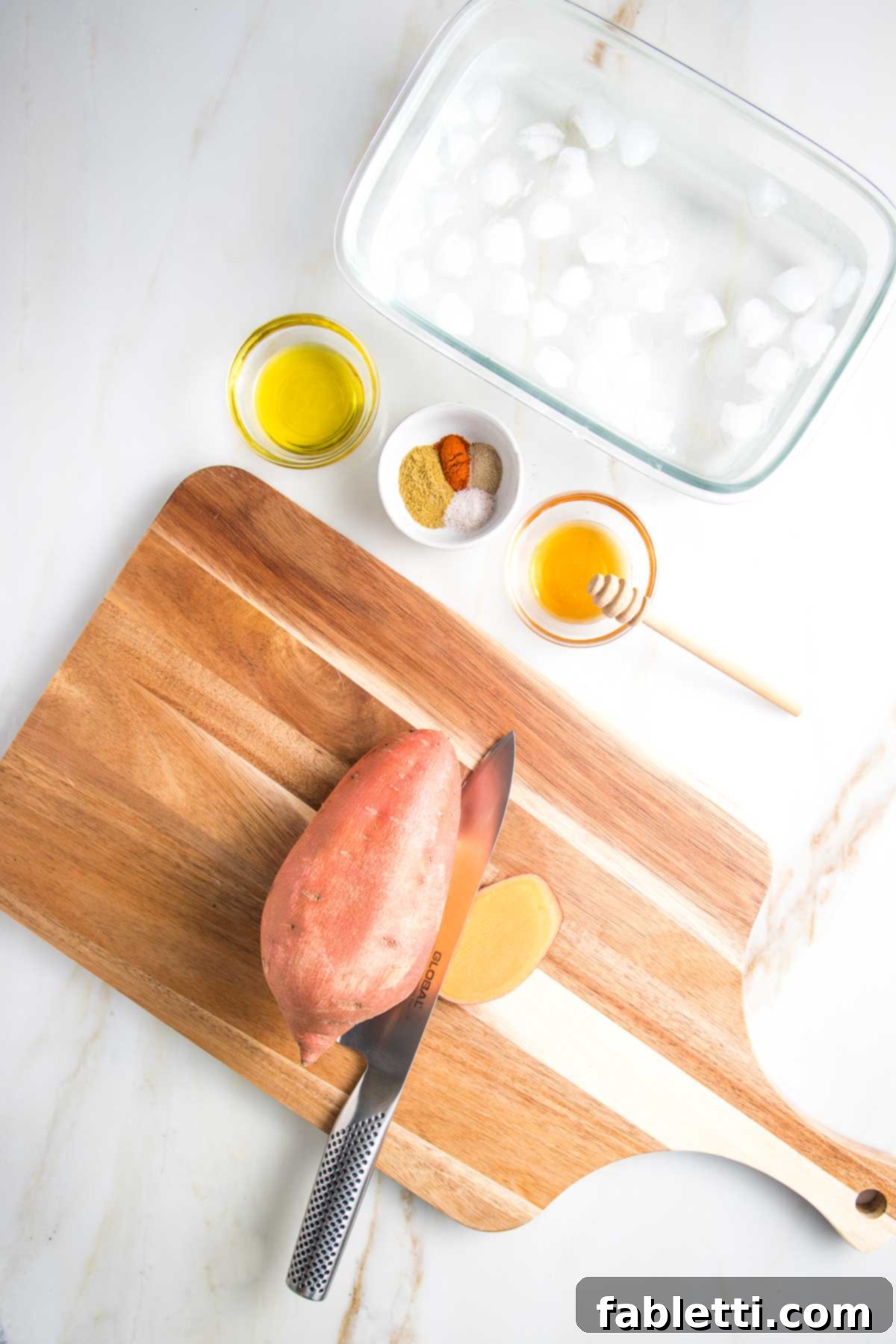 Golden Crispy Sweet Potato Fries 3 Cutting board with a sweet potato with a sliver cut off one lengthwise side.