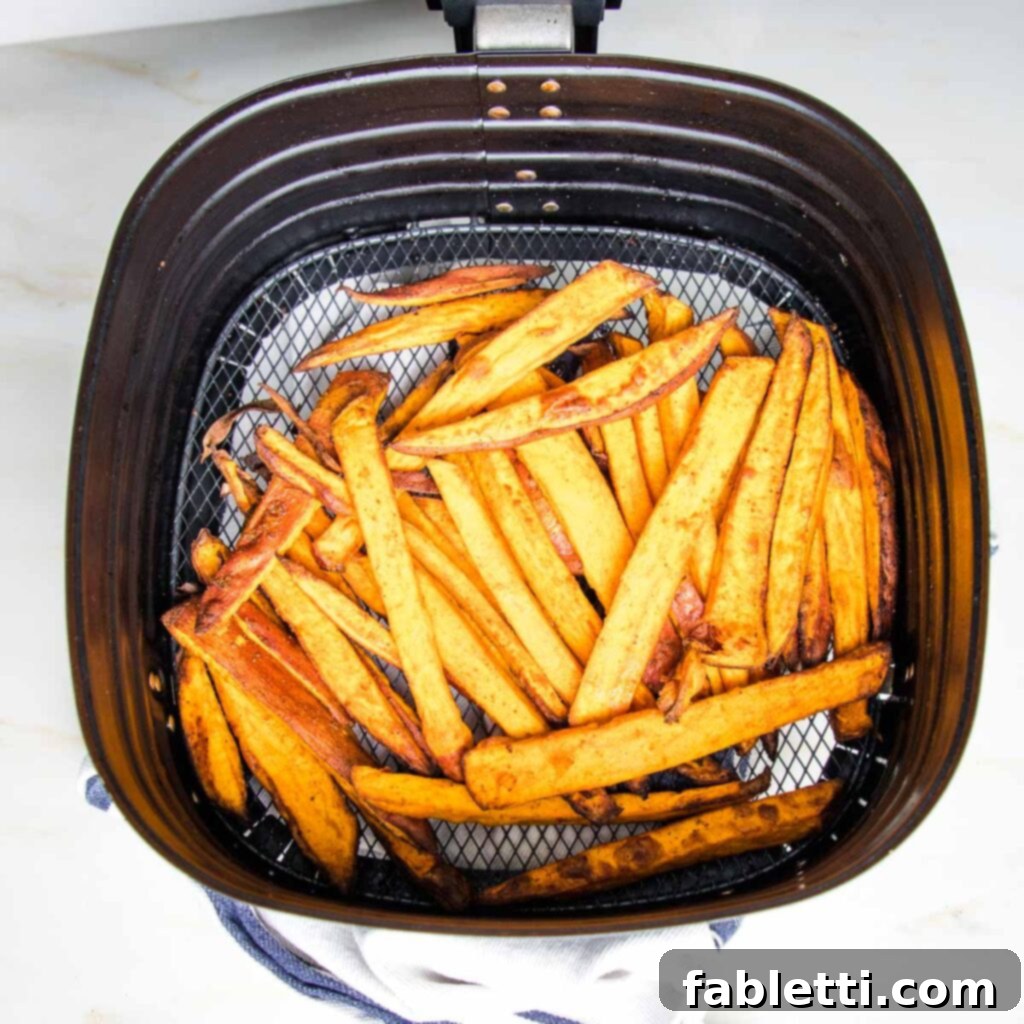 Golden Crispy Sweet Potato Fries 9 Crispy sweet potato fries in an air fryer basket.