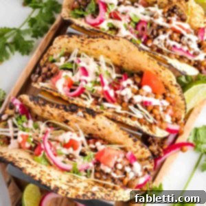 Hearty Vegan Lentil Tacos 12 Bright colorful tacos filled with lentils, pickled onions, cabbage, tomatoes and drizzled with hot sauce.