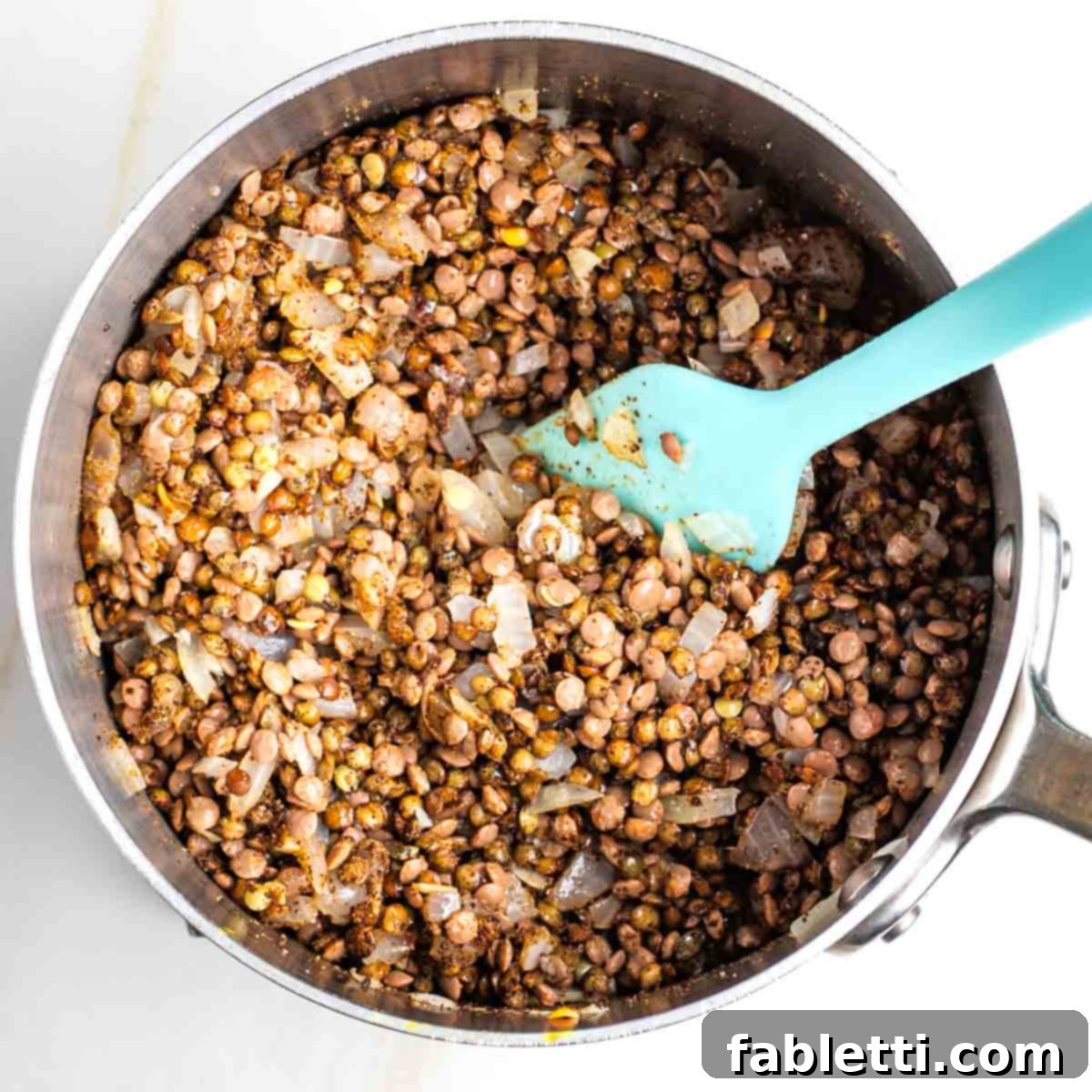 Hearty Vegan Lentil Tacos 6 Lentil mixture being thoroughly mixed to ensure even spice coating.