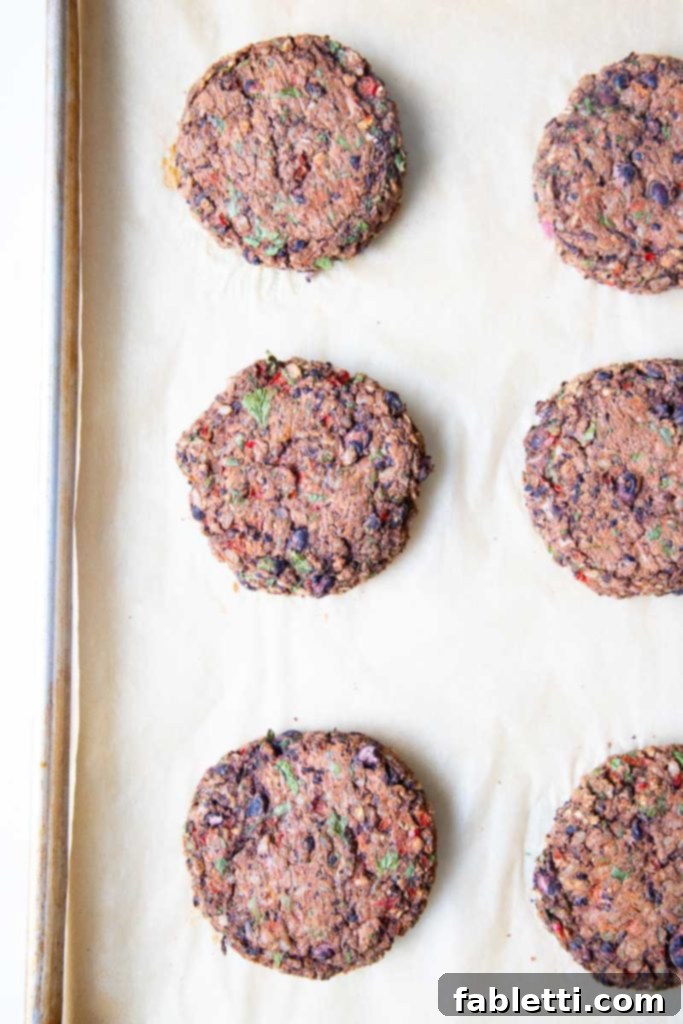 Plant-Powered Black Bean Burgers 10 A baking tray with perfectly cooked black bean veggie burgers, golden-brown and firm, ready to be served.