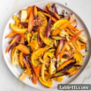 Nectar-Kissed Roasted Roots 11 Plate filled with colorful roasted carrots and parsnips with oranges, garnished and ready to serve.