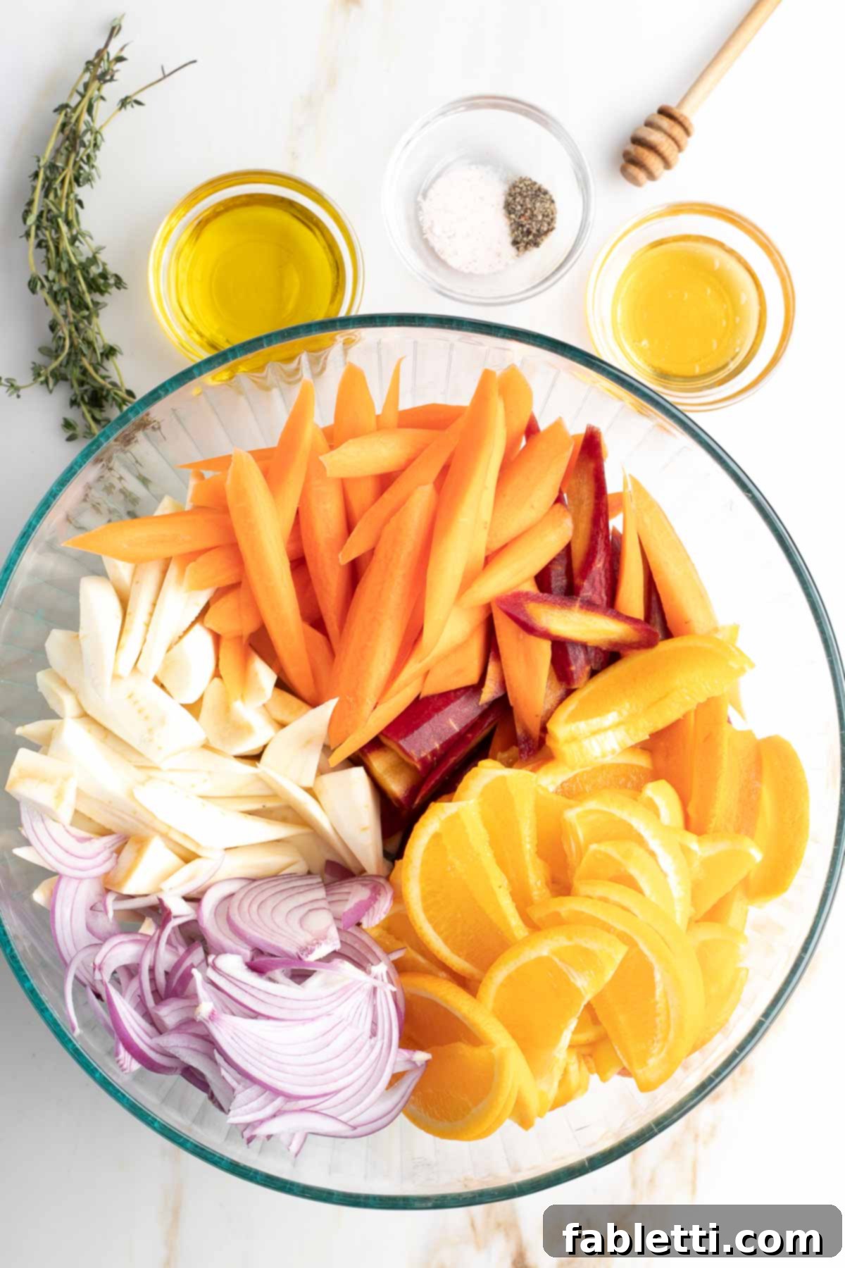Nectar-Kissed Roasted Roots 6 Bowl of colorful sliced veggies, plus olive oil, honey, spices and fresh thyme arranged nearby.