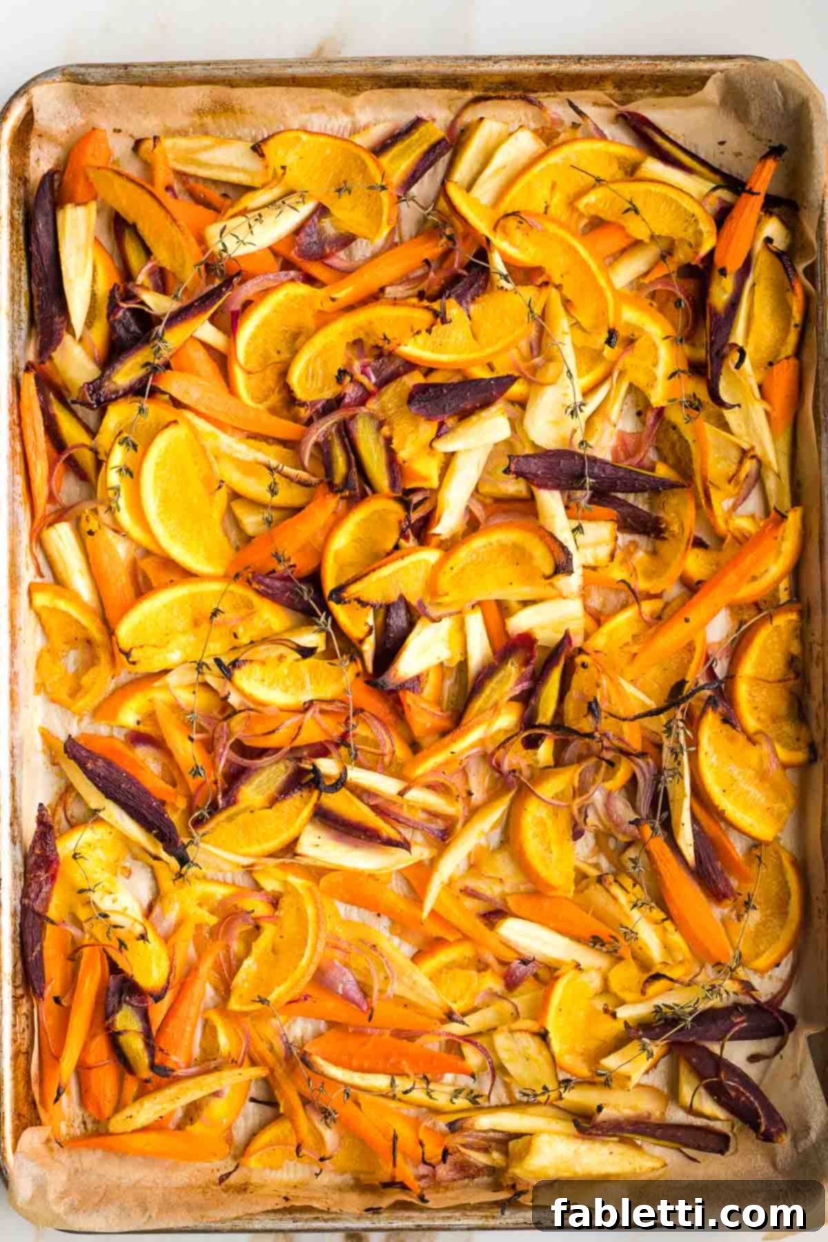 Nectar-Kissed Roasted Roots 9 Honey roasted parsnips, carrots, oranges and onions on a parchment lined baking tray, golden brown and tender.