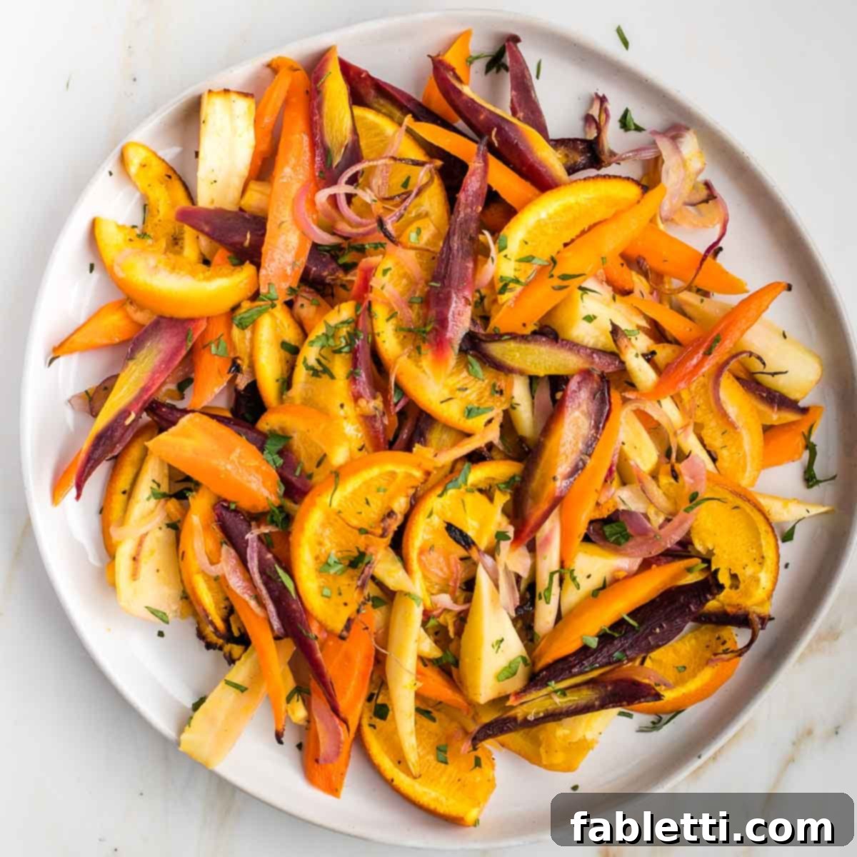 Nectar-Kissed Roasted Roots 10 A vibrant platter of honey roasted carrots, parsnips, oranges, and onions, garnished with fresh herbs, ready to be served.