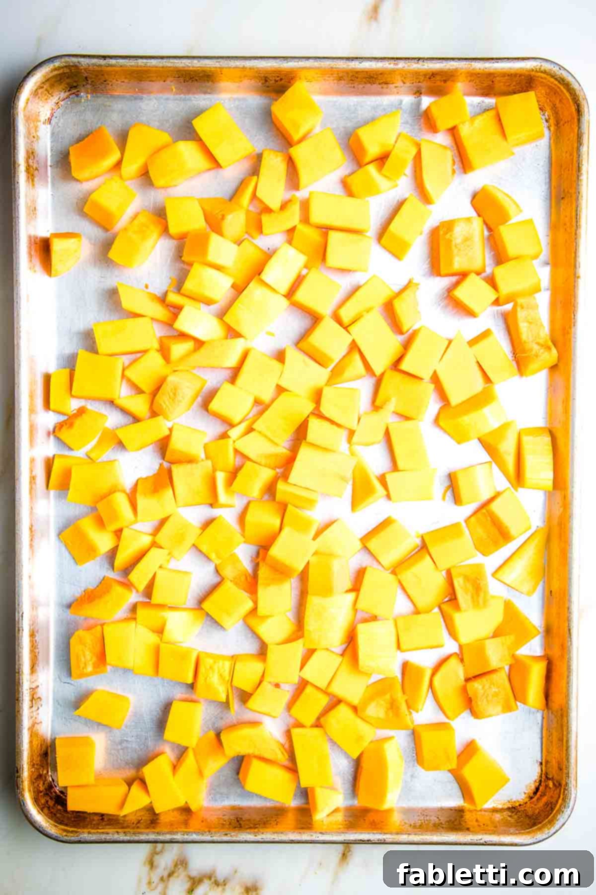 Vibrant Butternut Beetroot Medley 9 Large rimmed baking tray with cubes of butternut squash.