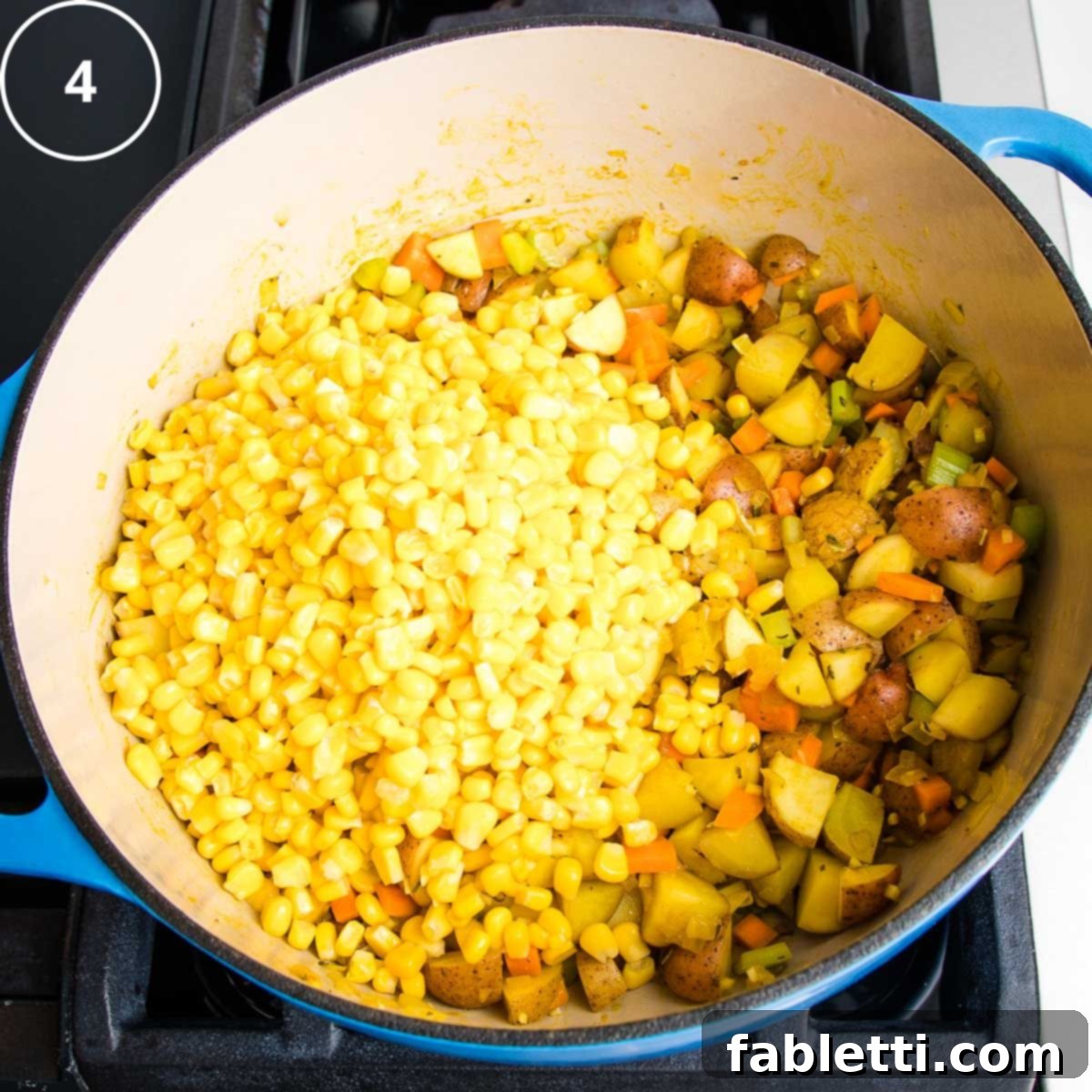 Fresh corn kernels are added to the sautéed vegetables in the Dutch oven, creating a colorful mix.