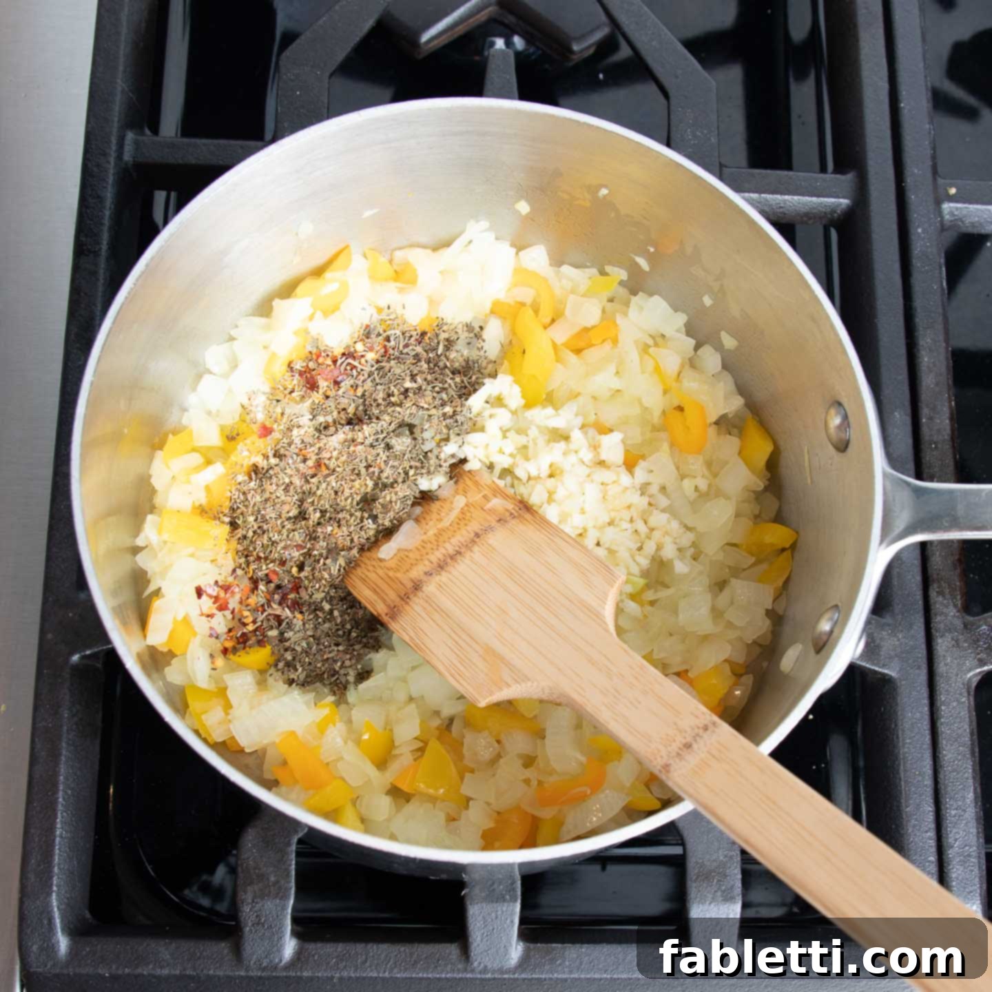Hearty Vegan Lentil Stuffed Peppers 8 Onions and bell pepper scraps being sautéed in a skillet with spices and garlic.