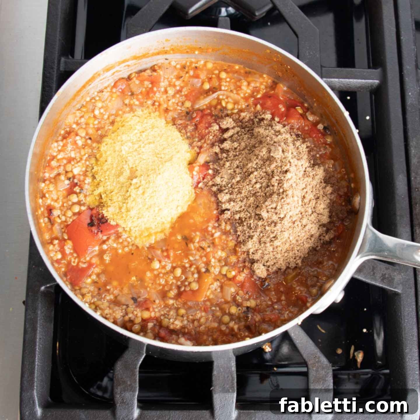 Hearty Vegan Lentil Stuffed Peppers 10 Vegetable stock being added to the quinoa, lentils, and tomato mixture, then simmering.