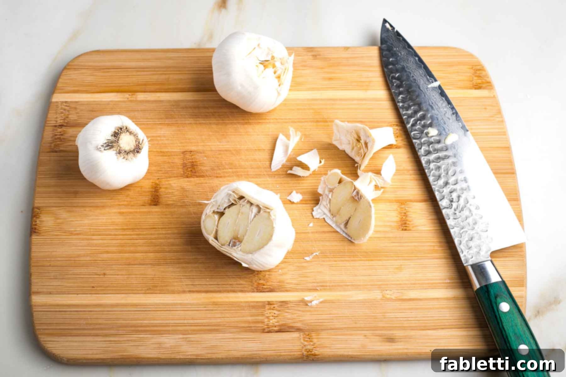 Sweet Creamy Oven Roasted Garlic 4 A whole head of garlic with the top sliced off, exposing the flesh of the individual cloves.