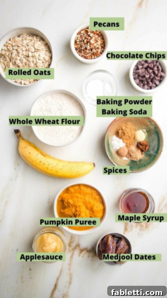 Harvest Spice Vegan Banana Loaf 4 Clearly labeled ingredients for vegan banana pumpkin bread including rolled oats, whole wheat flour, pecans, chocolate chips, spices, pumpkin puree, maple syrup, applesauce, and dates.