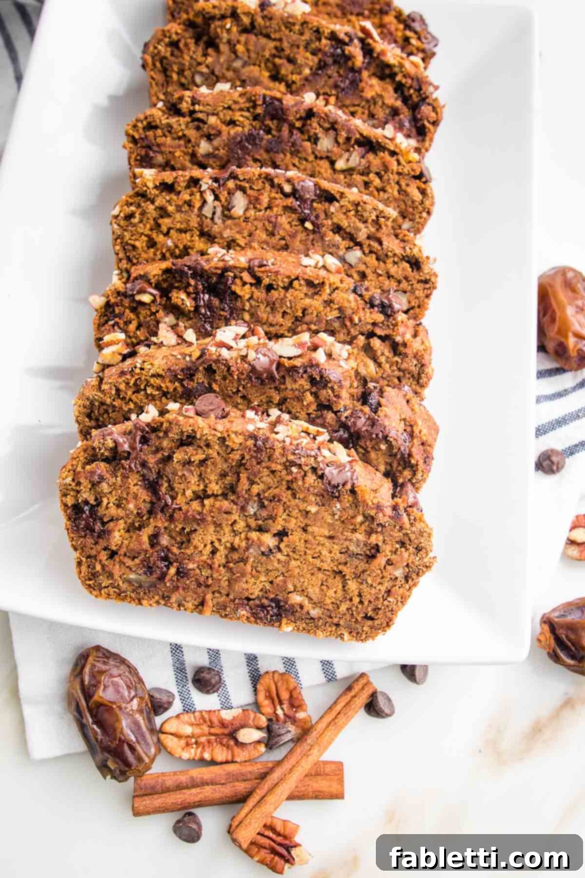 Harvest Spice Vegan Banana Loaf 3 Perfectly sliced vegan pumpkin bread with visible chocolate chips, served on a white plate.