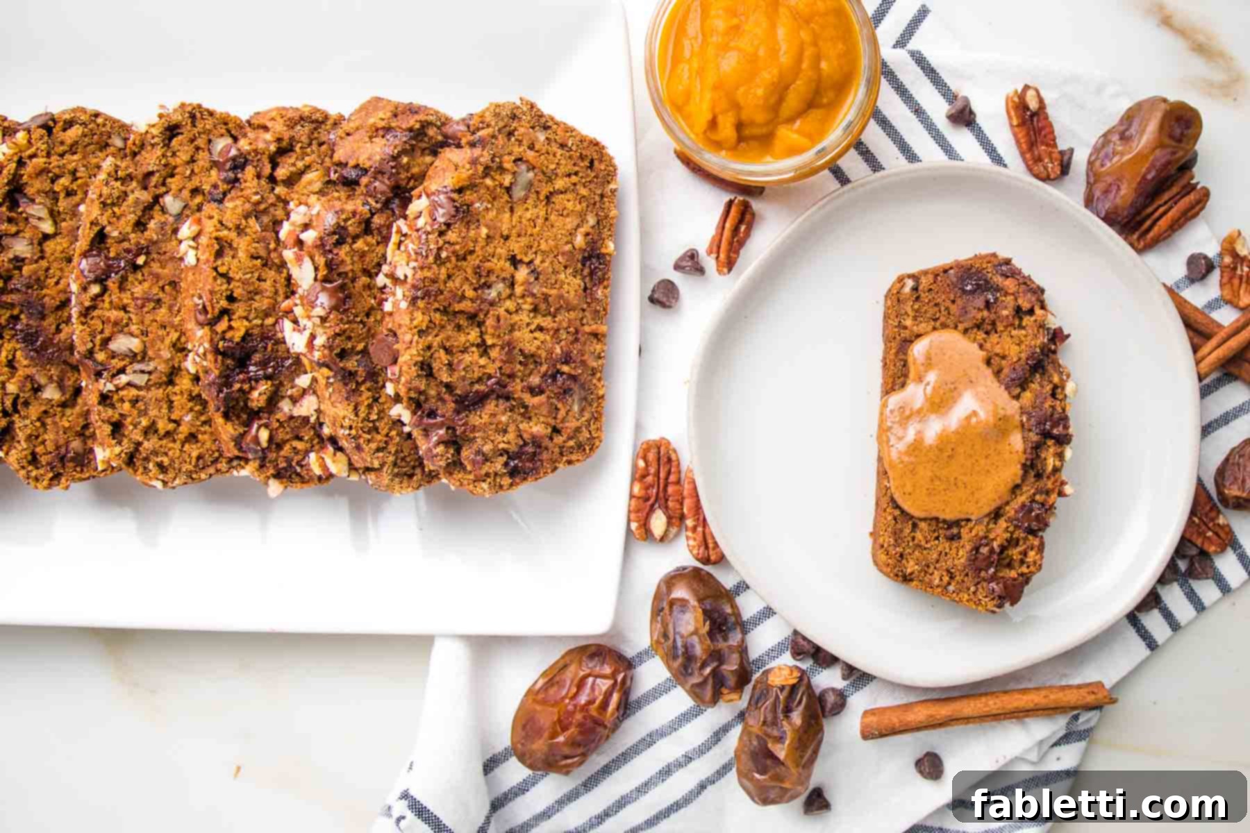 Harvest Spice Vegan Banana Loaf 10 Slices of fluffy pumpkin bread, with one slice on a plate accompanied by a generous dollop of almond butter, creating a perfect breakfast or snack.