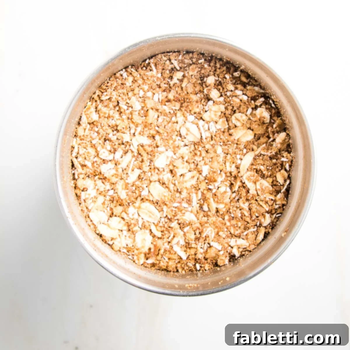 Naturally Sweet Dairy-Free Baked Apples 11 The wholesome oatmeal mixture for the baked apples, finely ground in a spice grinder, showcasing its uniform, crumbly texture, ready for the next step.