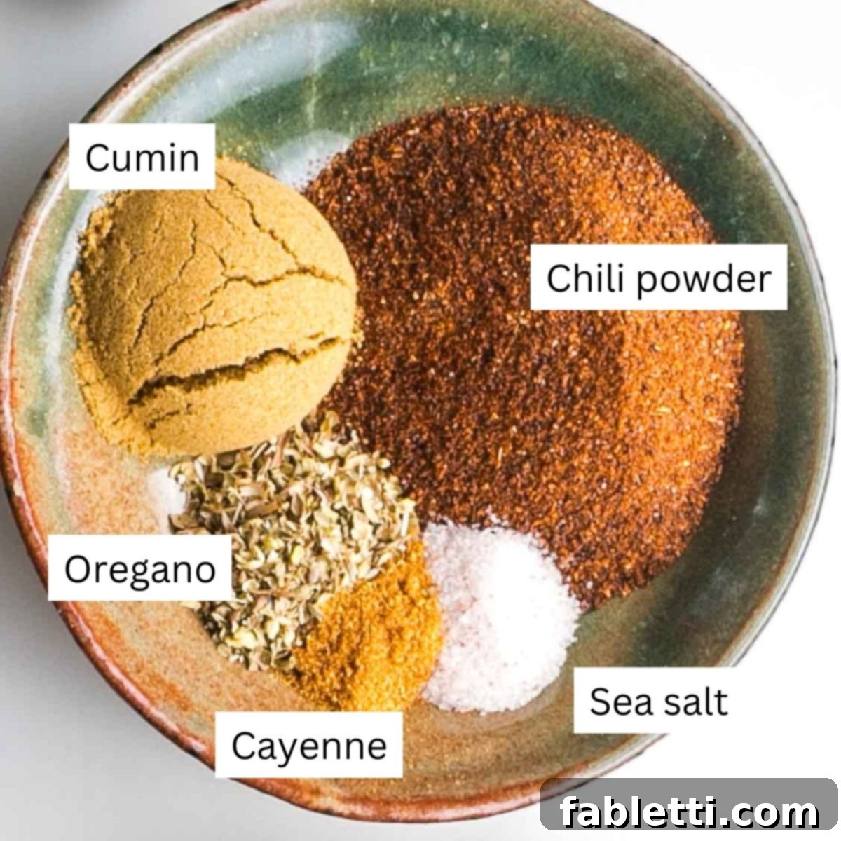 Quick and Flavorful Vegan Lentil Chili 7 Individual bowls of chili spices neatly labeled: cumin, chili powder, oregano, cayenne pepper, and sea salt, ready to be added to the pot.