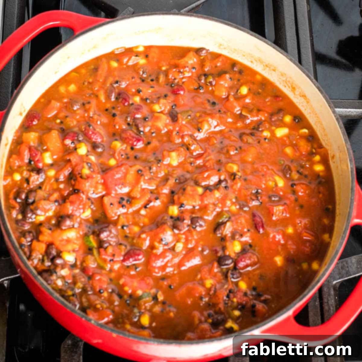 Quick and Flavorful Vegan Lentil Chili 9 A rich, bubbling pot of vegan lentil chili simmering on the stovetop in a Dutch oven, filling the kitchen with its delicious aroma.