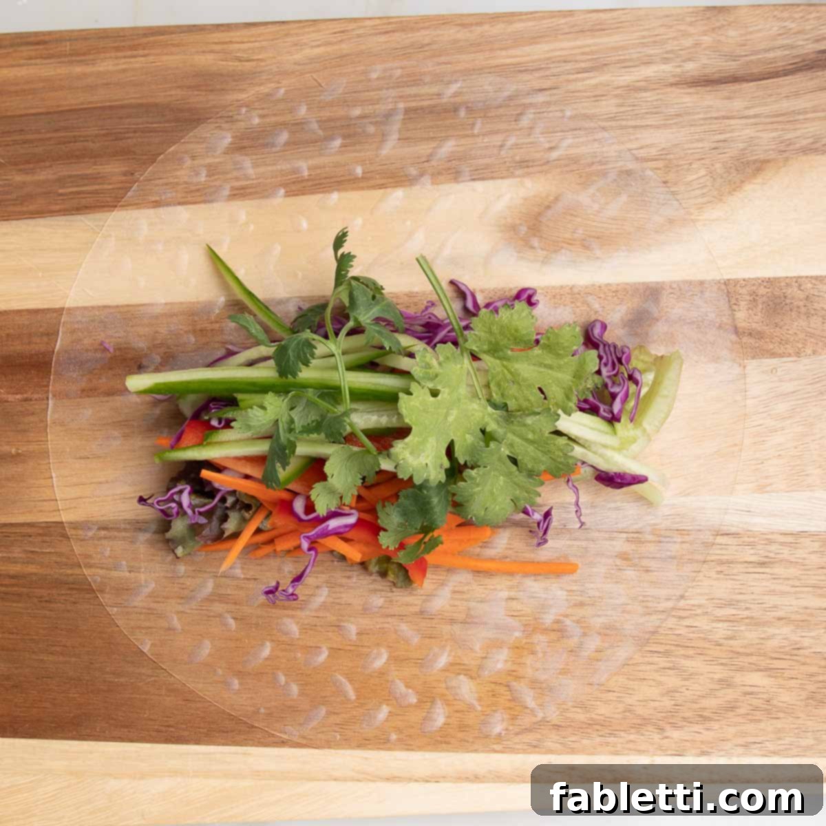 A rice paper wrapper generously filled in the center with an array of fresh, colorful vegetables.