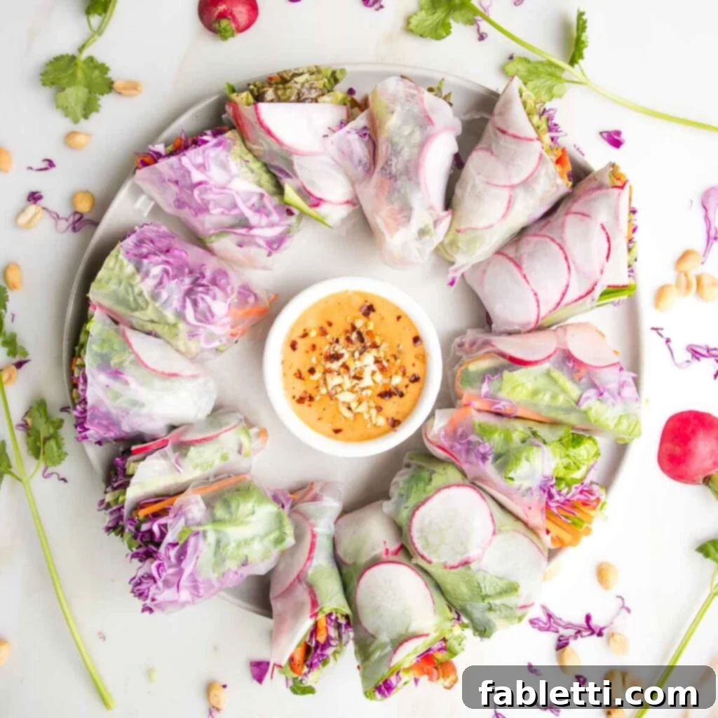 A round serving platter featuring a small bowl of rich peanut dipping sauce at its center, surrounded by a vibrant circle of freshly prepared spring rolls.