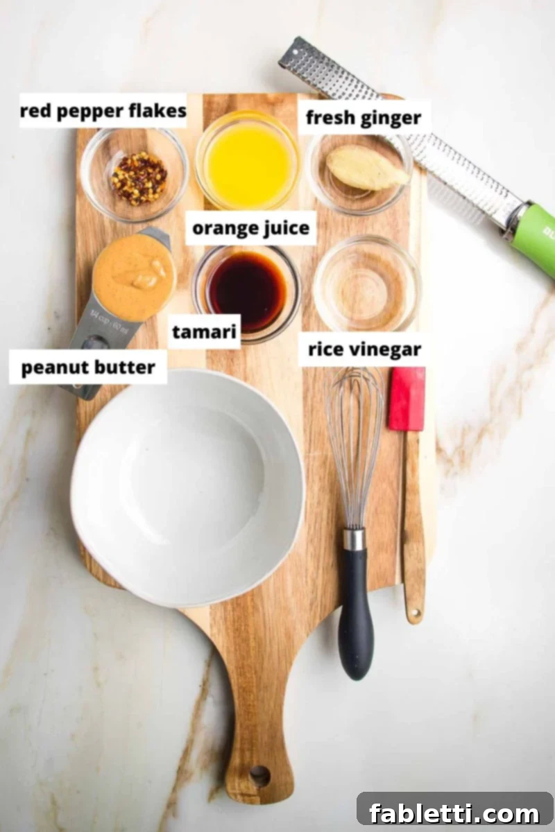 Labeled ingredients for a vibrant peanut dipping sauce: crushed red pepper flakes, fresh orange juice, aromatic fresh ginger, creamy peanut butter, savory tamari, and tangy rice vinegar.
