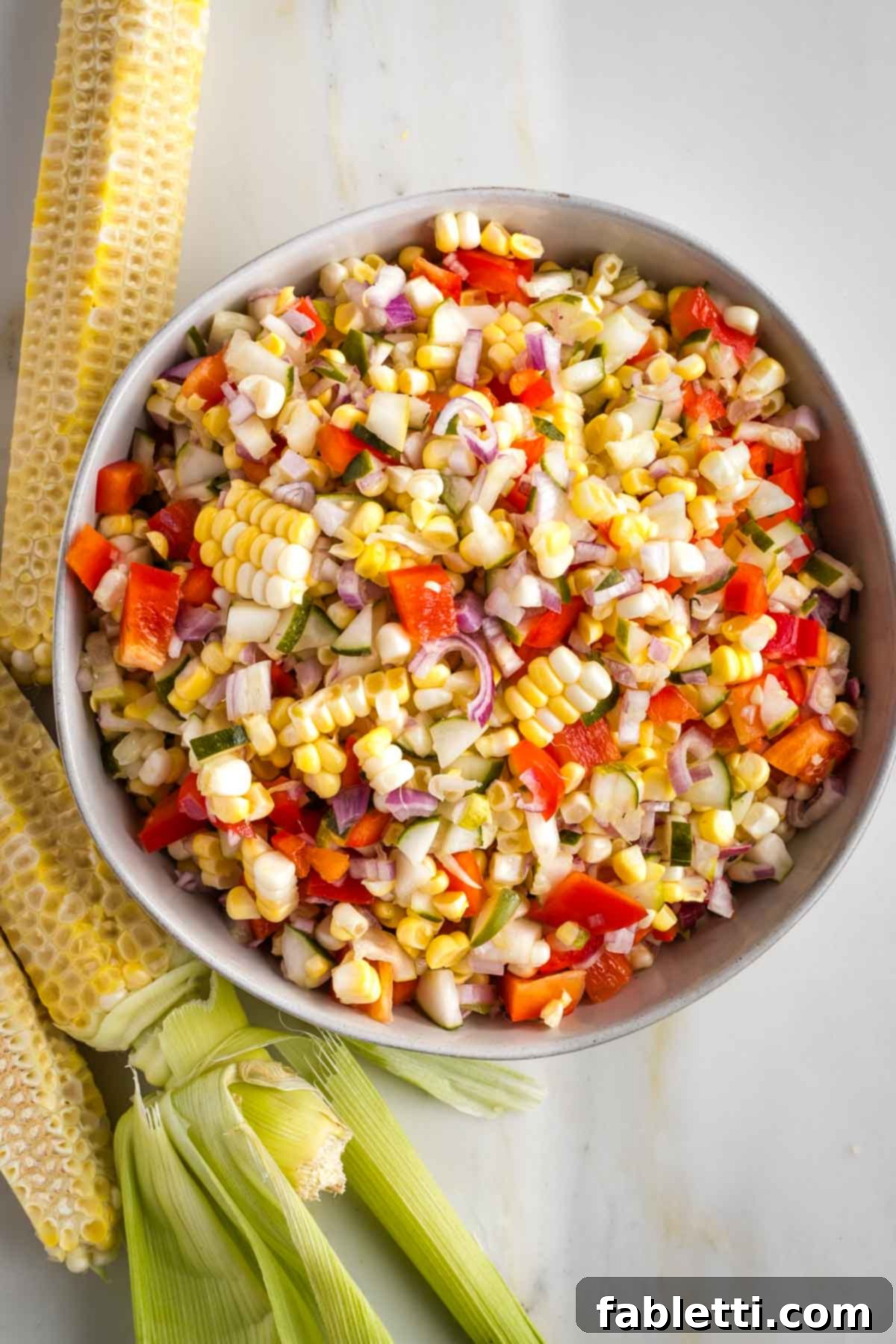Zesty Israeli Corn and Pickle Salad 2 Freshly cut corn kernels mixed with diced pickles, vibrant red bell peppers, and finely chopped shallots, creating a colorful and appetizing Israeli corn and pickle salad.