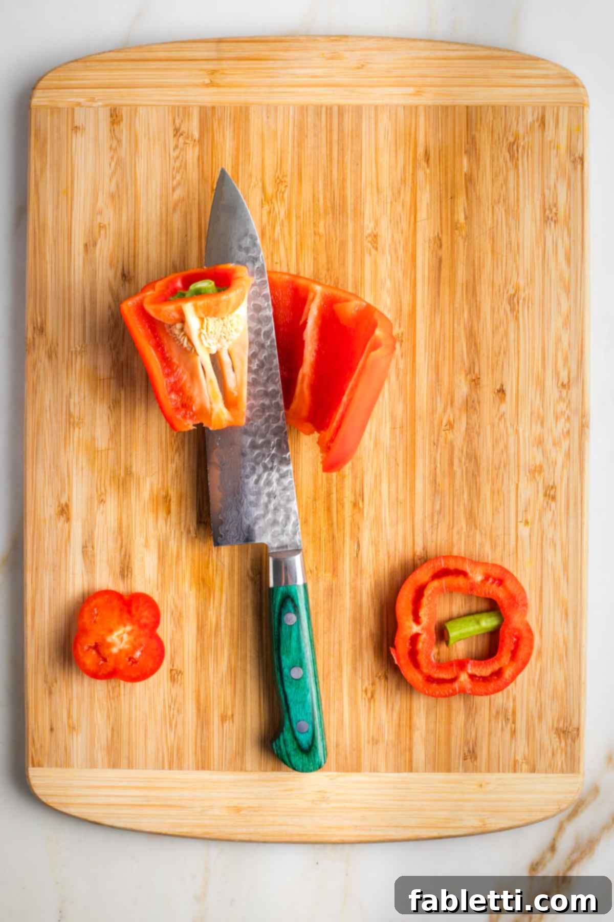 Zesty Israeli Corn and Pickle Salad 7 A red bell pepper being prepped, with its core and seeds carefully removed before dicing.
