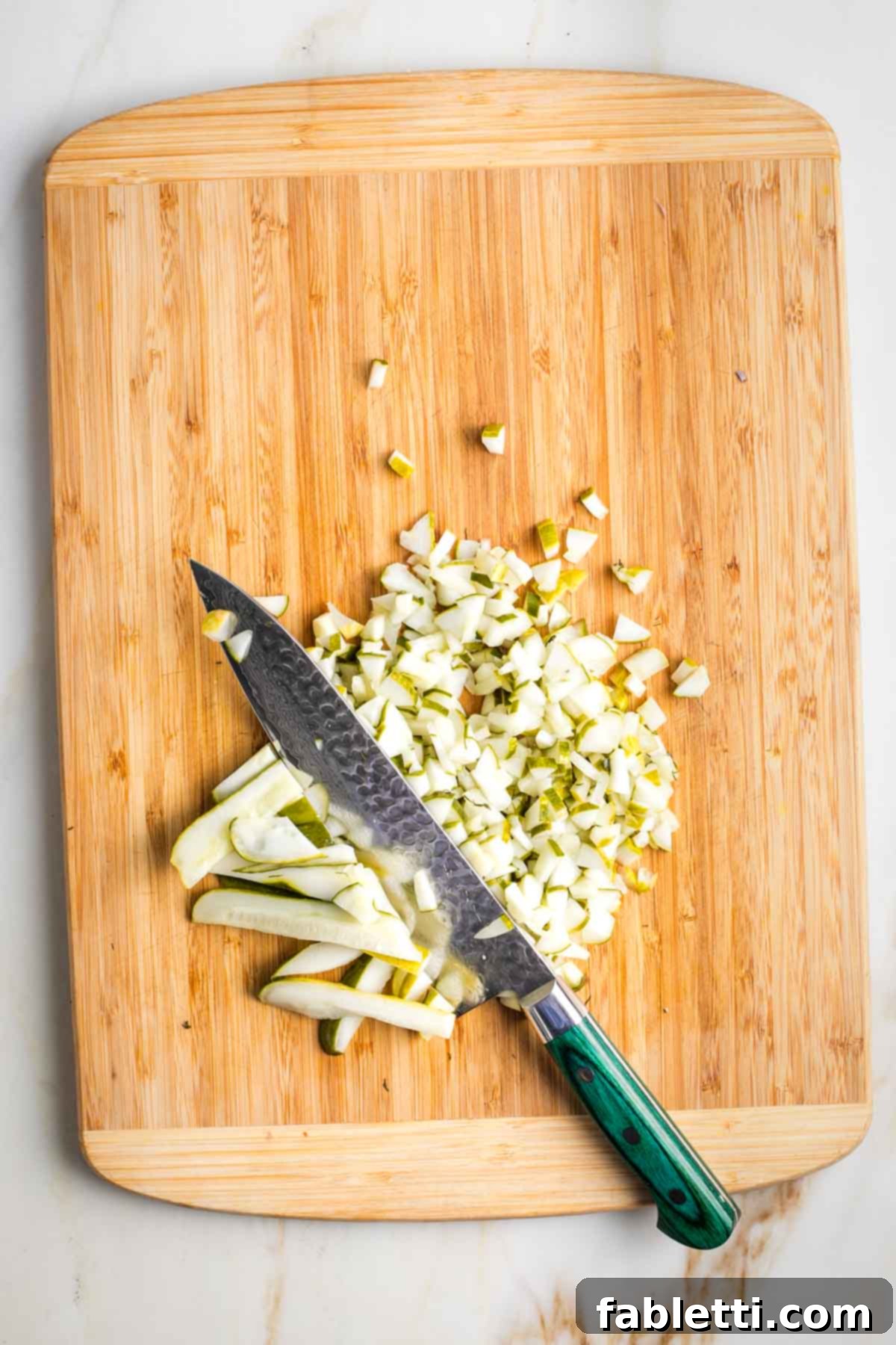 Zesty Israeli Corn and Pickle Salad 8 Drained pickle slices being lined up on a cutting board, ready to be cut into small, uniform dice.