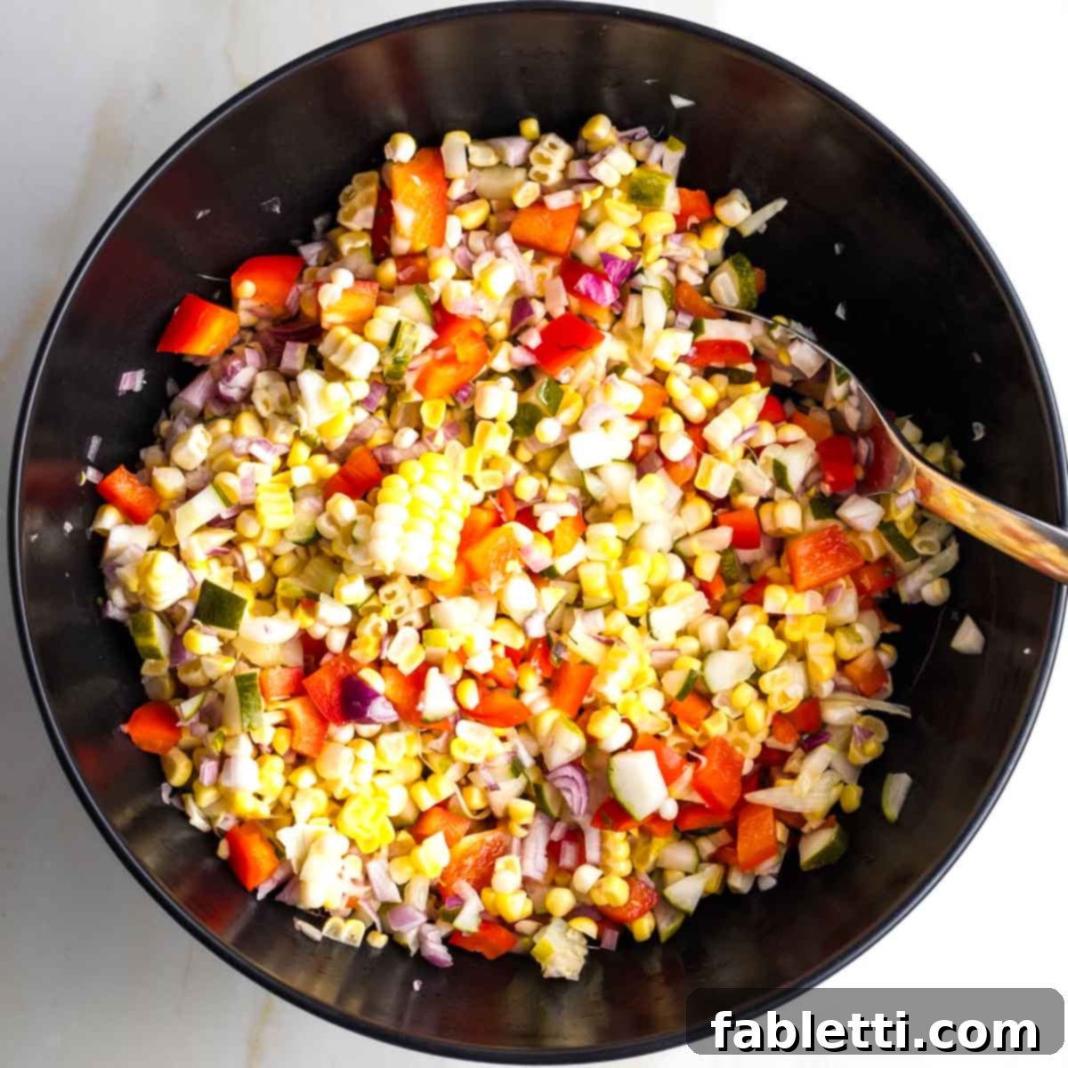 Zesty Israeli Corn and Pickle Salad 10 A vibrant and colorful Israeli corn and pickle salad, featuring red peppers and shallots, perfectly mixed and ready to serve.